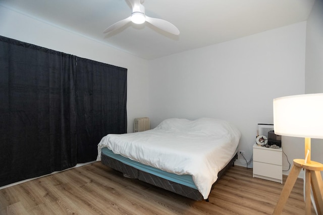 932 W Sunnyside Ave Unit 1C, Chicago, IL 60640 - bedroom featuring radiator heating unit, light wood-style floors, and ceiling fan