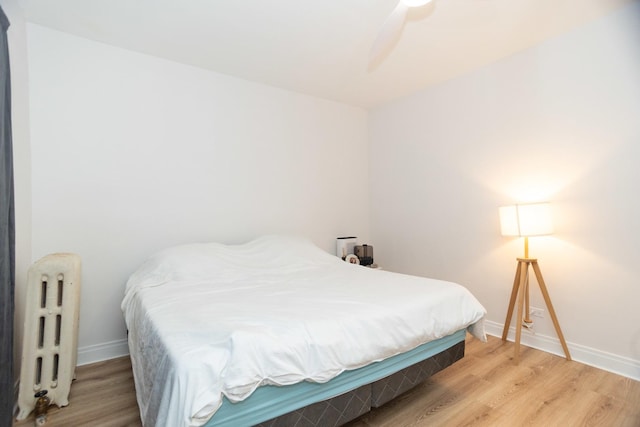 932 W Sunnyside Ave Unit 1C, Chicago, IL 60640 - bedroom featuring radiator, light wood-style floors, and baseboards