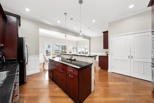 6205 W Grace St, Chicago, IL 60634 - kitchen with freestanding refrigerator, ornamental molding, light wood finished floors, a wainscoted wall, and a kitchen island