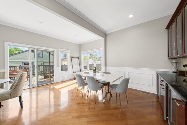 6205 W Grace St, Chicago, IL 60634 - dining room with dark wood finished floors, wainscoting, crown molding, a decorative wall, and recessed lighting