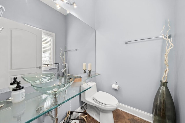 6205 W Grace St, Chicago, IL 60634 - bathroom featuring toilet, a sink, baseboards, and tile patterned flooring