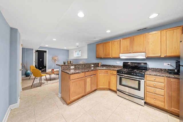 6205 W Grace St, Chicago, IL 60634 - kitchen with stainless steel gas range, under cabinet range hood, a peninsula, dark stone counters, and recessed lighting