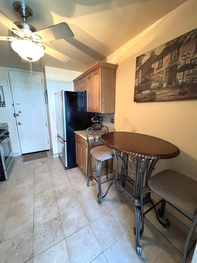 6700 S S Shore Dr Unit 17A, Chicago, IL 60649 - kitchen with appliances with stainless steel finishes, ceiling fan, light tile patterned floors, and brown cabinetry