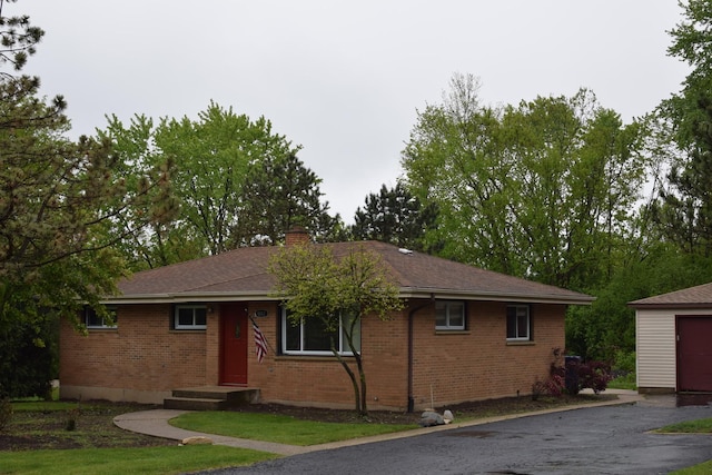 1012 Elsie Ave, Gurnee, IL 60031 - ranch-style home featuring brick siding, a chimney, an outbuilding, driveway, and a shingled roof