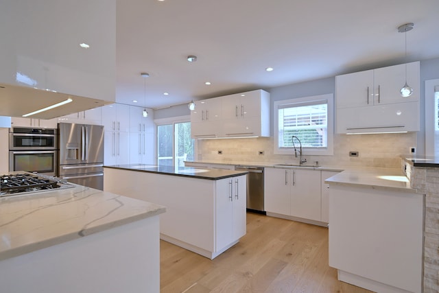 3548 Grandmore Ave, Gurnee, IL 60031 - kitchen with appliances with stainless steel finishes, a sink, light wood-style flooring, a kitchen island, and white cabinetry