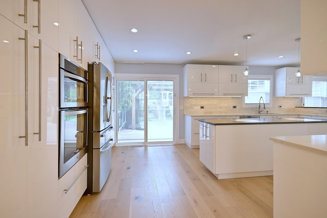 3548 Grandmore Ave, Gurnee, IL 60031 - kitchen featuring modern cabinets, stainless steel fridge with ice dispenser, light wood-style floors, a sink, and decorative backsplash