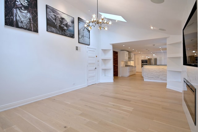 3548 Grandmore Ave, Gurnee, IL 60031 - unfurnished living room with light wood-style floors, baseboards, a skylight, a chandelier, and high vaulted ceiling
