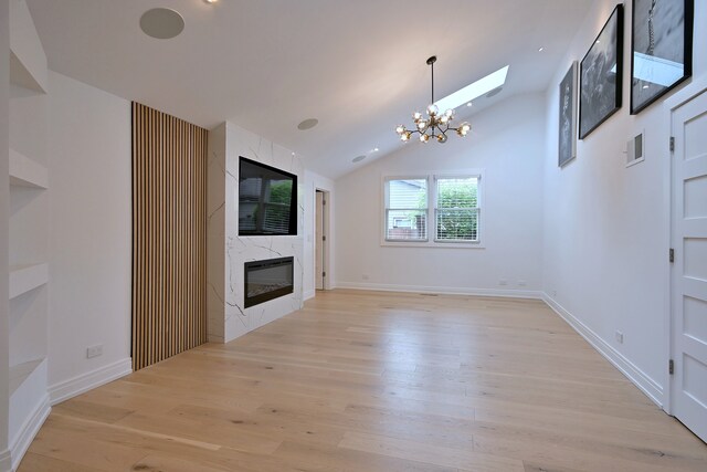 3548 Grandmore Ave, Gurnee, IL 60031 - unfurnished living room featuring a chandelier, a fireplace, light wood finished floors, vaulted ceiling, and baseboards