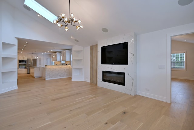 3548 Grandmore Ave, Gurnee, IL 60031 - unfurnished living room with light wood-style floors, a chandelier, baseboards, a fireplace, and built in shelves