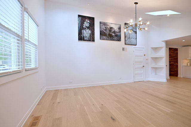 3548 Grandmore Ave, Gurnee, IL 60031 - unfurnished dining area featuring light wood-type flooring, a chandelier, built in features, and baseboards