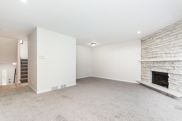 334 Ashland Ave, Highwood, IL 60040 - unfurnished living room with stairway, carpet flooring, a stone fireplace, and baseboards
