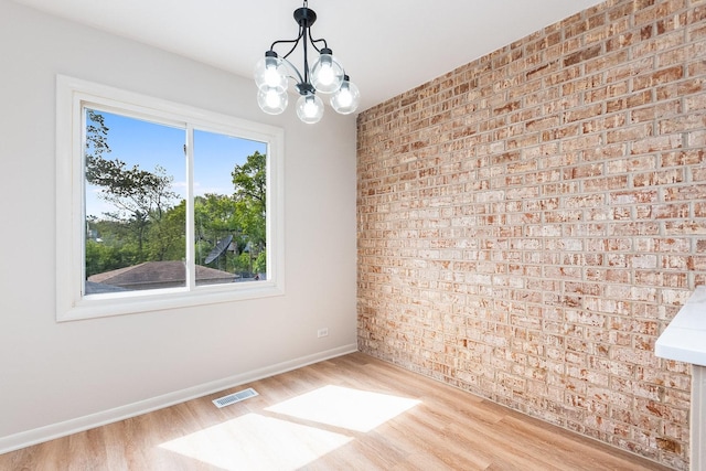334 Ashland Ave, Highwood, IL 60040 - unfurnished room with brick wall, wood finished floors, baseboards, and a chandelier