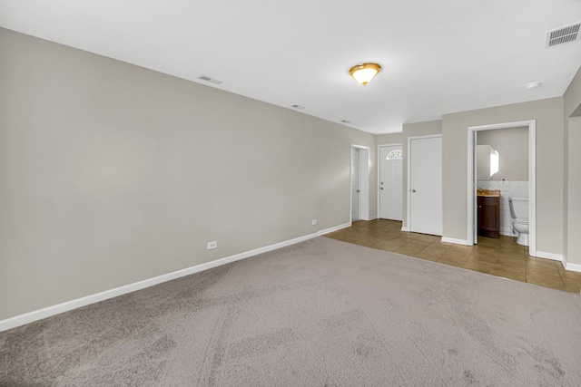 1455 Reckinger Rd, Aurora, IL 60505 - unfurnished bedroom featuring carpet floors, baseboards, tile patterned floors, and ensuite bathroom