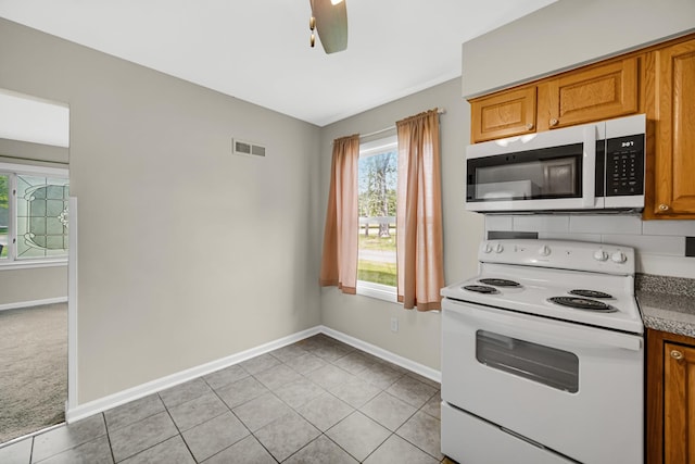 1455 Reckinger Rd, Aurora, IL 60505 - kitchen featuring white appliances, baseboards, brown cabinetry, and light tile patterned floors