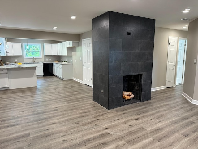 363 Indianwood Blvd, Park Forest, IL 60466 - kitchen with black dishwasher, light wood-style floors, white cabinetry, recessed lighting, and a tiled fireplace