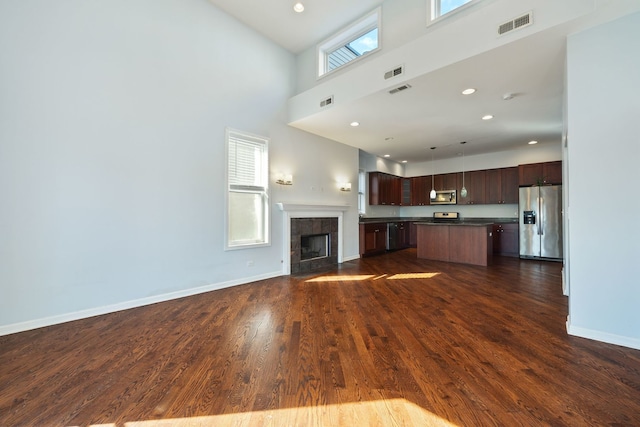 4800 S St Lawrence Ave Unit 3S, Chicago, IL 60615 - unfurnished living room featuring dark wood-style floors, a high ceiling, a tiled fireplace, and recessed lighting