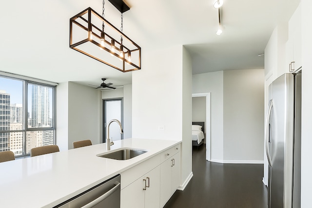 123 S Green St Unit 1101B, Chicago, IL 60607 - kitchen featuring appliances with stainless steel finishes, a sink, light countertops, white cabinets, and decorative light fixtures