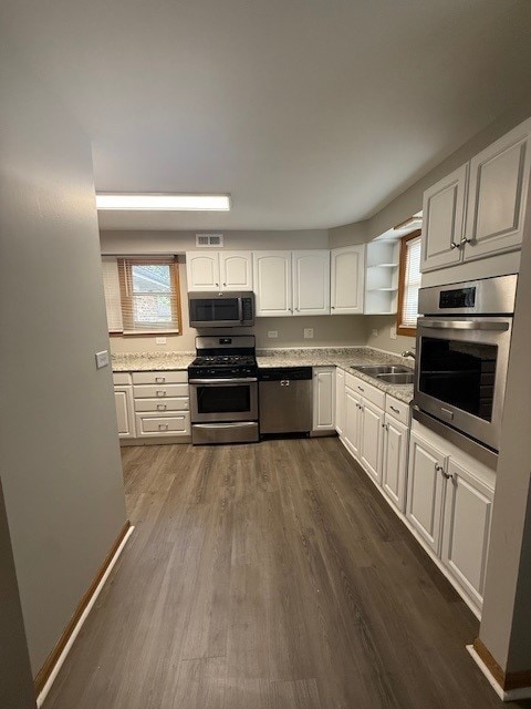 674 E Algonquin Rd, Des Plaines, IL 60016 - kitchen featuring appliances with stainless steel finishes, a sink, dark wood-style floors, white cabinets, and healthy amount of natural light