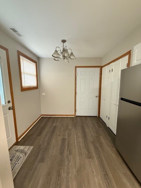674 E Algonquin Rd, Des Plaines, IL 60016 - unfurnished dining area featuring a chandelier, dark wood-style floors, and baseboards