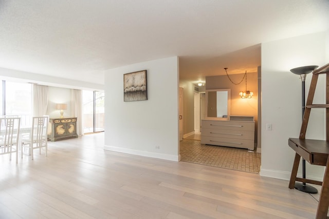 2 S Atrium Way Unit 208, Elmhurst, IL 60126 - empty room with a chandelier, wood finished floors, and baseboards