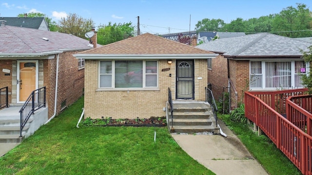 3052 E 97th St, Chicago, IL 60617 - bungalow with brick siding, a front lawn, a chimney, and roof with shingles