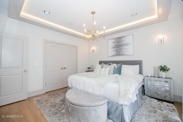 1221 E 46th St Unit 1, Chicago, IL 60653 - bedroom featuring a raised ceiling, a chandelier, wood finished floors, and a closet