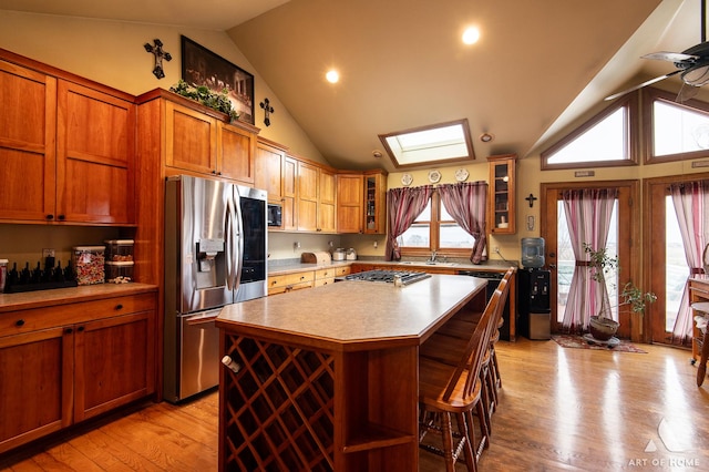 17207 Chase Rd, Dekalb, IL 60115 - kitchen with appliances with stainless steel finishes, a skylight, a center island, light countertops, and brown cabinets