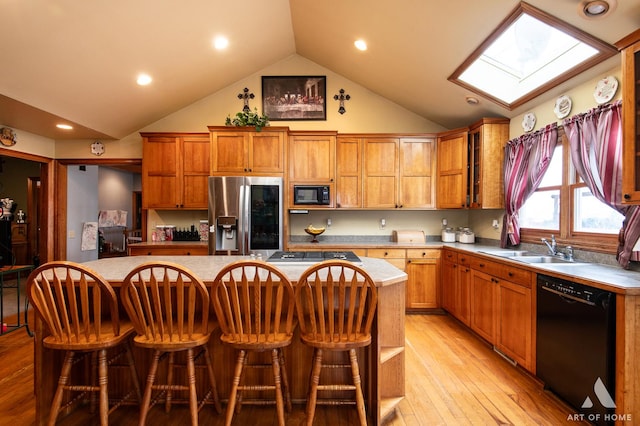 17207 Chase Rd, Dekalb, IL 60115 - kitchen with black appliances, a center island, a sink, a skylight, and high vaulted ceiling