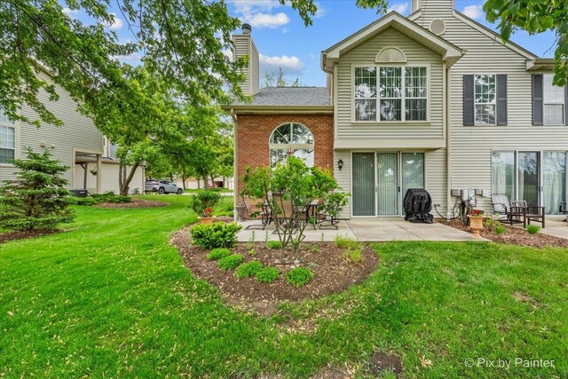 184 Golfview Dr, Glendale Heights, IL 60139 - rear view of house with a chimney, a patio, a yard, and brick siding
