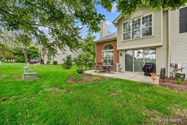184 Golfview Dr, Glendale Heights, IL 60139 - rear view of house with a patio, a chimney, a yard, and brick siding