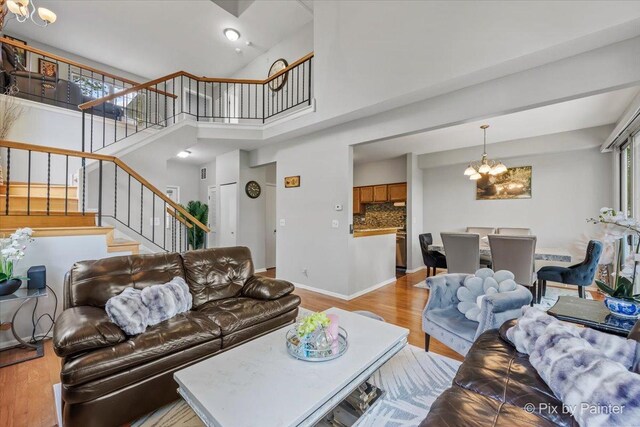 184 Golfview Dr, Glendale Heights, IL 60139 - living area featuring a chandelier, stairs, wood finished floors, a towering ceiling, and baseboards
