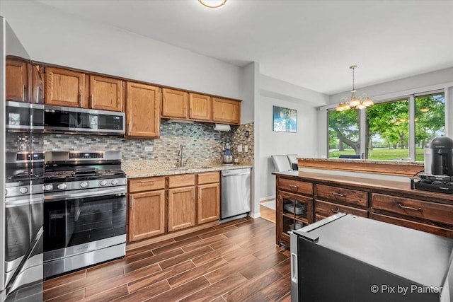 184 Golfview Dr, Glendale Heights, IL 60139 - kitchen with stainless steel appliances, a sink, decorative backsplash, dark wood-style flooring, and decorative light fixtures