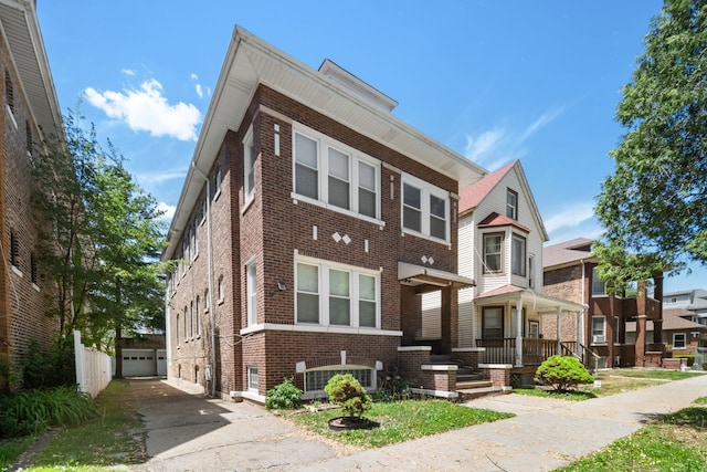 8548 S Exchange Ave, Chicago, IL 60617 - view of front facade featuring brick siding, driveway, and an outbuilding