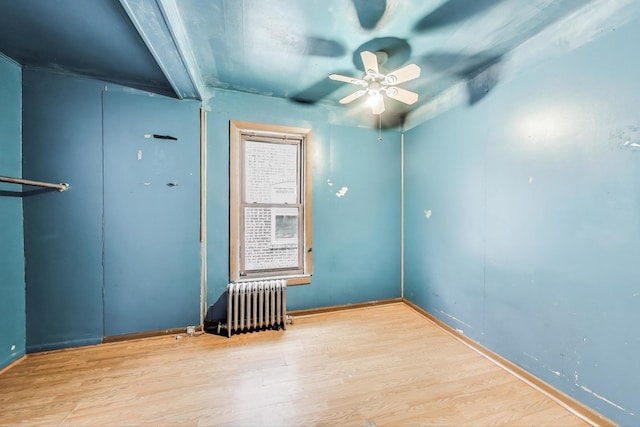 7649 S Dobson Ave, Chicago, IL 60619 - empty room featuring radiator heating unit, wood finished floors, a ceiling fan, and baseboards