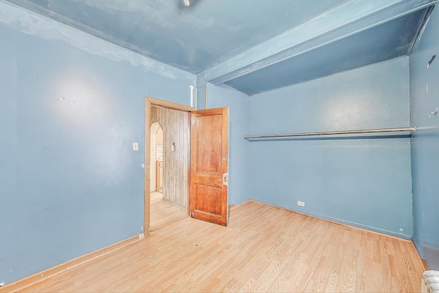 7649 S Dobson Ave, Chicago, IL 60619 - unfurnished bedroom with wood finished floors, arched walkways, and baseboards