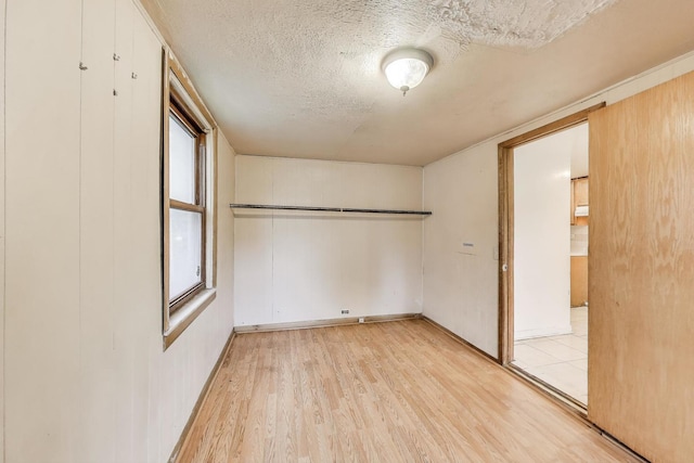 7649 S Dobson Ave, Chicago, IL 60619 - empty room featuring a textured ceiling and light wood-style floors
