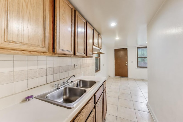 7649 S Dobson Ave, Chicago, IL 60619 - kitchen with light countertops, backsplash, light tile patterned floors, a sink, and brown cabinets