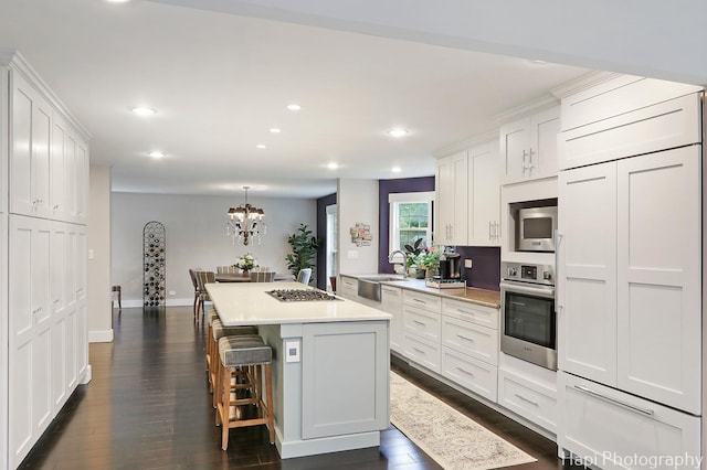 1116 Stonegate Ct, Bartlett, IL 60103 - kitchen featuring built in appliances, a center island, recessed lighting, light countertops, and white cabinetry