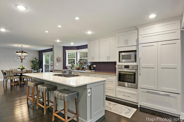 1116 Stonegate Ct, Bartlett, IL 60103 - kitchen with built in appliances, dark wood-type flooring, a center island, white cabinetry, and recessed lighting