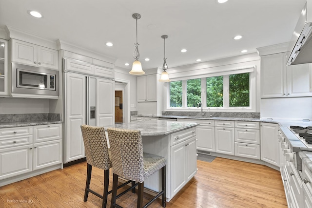 110 Inverway, Inverness, IL 60067 - kitchen with built in appliances, a breakfast bar area, white cabinetry, range hood, and recessed lighting