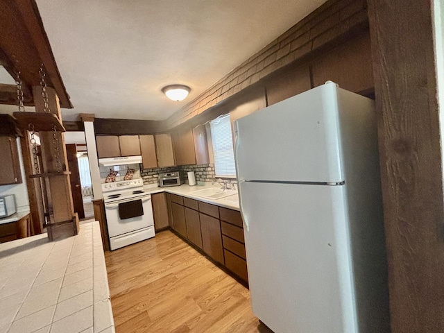 418 Starr St, Belvidere, IL 61008 - kitchen featuring white appliances, under cabinet range hood, a sink, light countertops, and light wood-type flooring