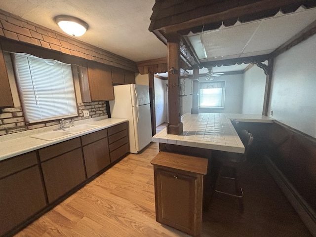 418 Starr St, Belvidere, IL 61008 - kitchen with a sink, freestanding refrigerator, tile counters, light wood-type flooring, and ceiling fan