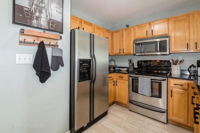 345 N Lasalle Dr Unit 802, Chicago, IL 60610 - kitchen with stainless steel appliances, dark countertops, and light wood-style flooring