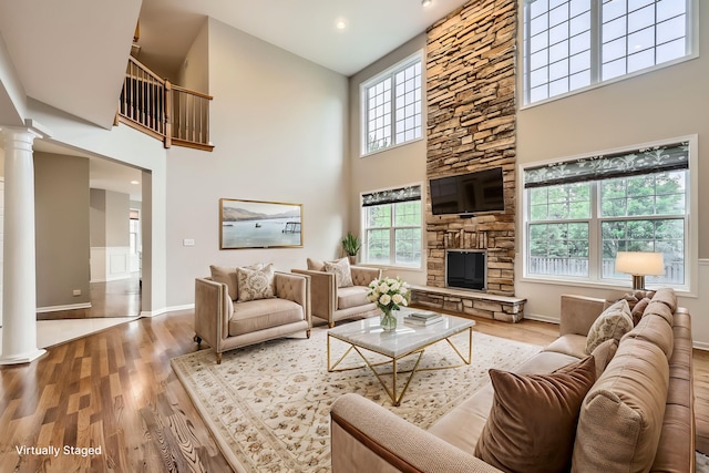 830 W Lukas Ave, Palatine, IL 60067 - living area featuring ornate columns, a towering ceiling, wood finished floors, a stone fireplace, and baseboards