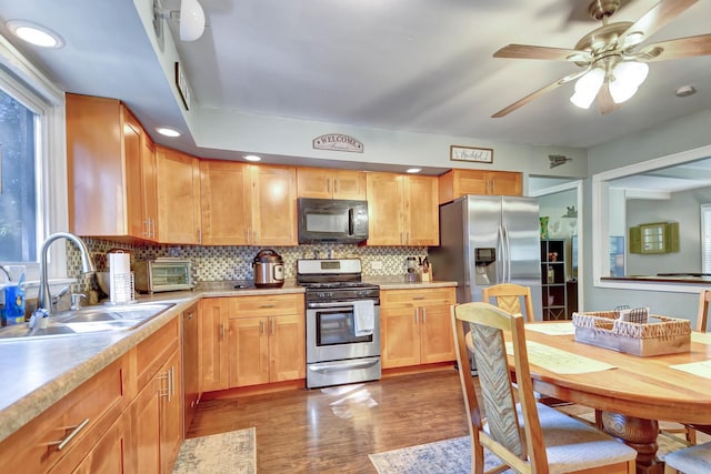 12599 S Archer Ave, Lemont, IL 60439 - kitchen featuring appliances with stainless steel finishes, a sink, dark wood-type flooring, decorative backsplash, and light countertops