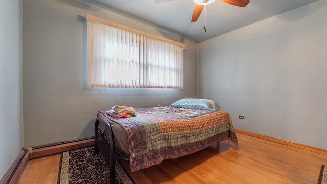 13122 S Escanaba Ave, Chicago, IL 60633 - bedroom with wood finished floors, baseboard heating, baseboards, and a ceiling fan