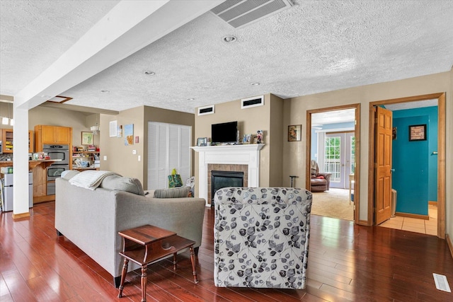 318 W Market St, Farmer City, IL 61842 - living room with a textured ceiling, dark wood finished floors, and a fireplace