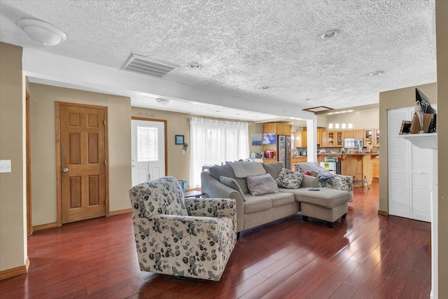 318 W Market St, Farmer City, IL 61842 - living room featuring a textured ceiling, dark wood-type flooring, and baseboards