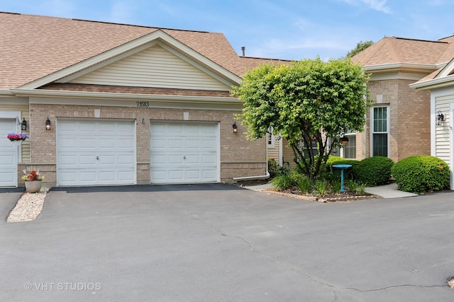 21513 W Douglas Ln, Plainfield, IL 60544 - view of front facade with asphalt driveway, brick siding, an attached garage, and a shingled roof