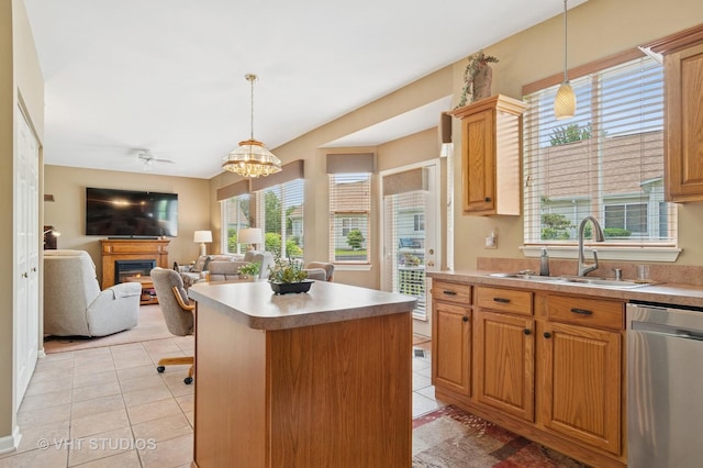 21513 W Douglas Ln, Plainfield, IL 60544 - kitchen featuring stainless steel dishwasher, a glass covered fireplace, light tile patterned floors, hanging light fixtures, and a kitchen island